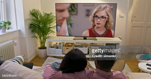 pareja viendo la televisión en casa - tv show fotografías e imágenes de stock