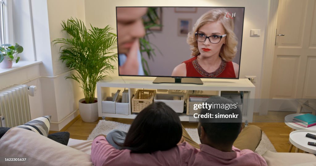 Couple watching TV at home