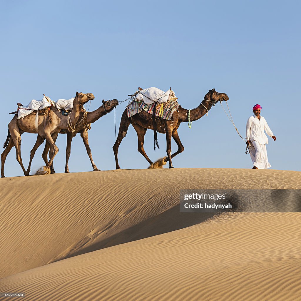 Indian man with camels during crossing sandunes