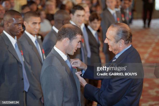 French President Jacques Chirac decorates Zinédine Zidane with the Legion of Honor, on September 1, 1998 at the Elysée Palace in Paris, during the...