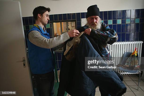 Botho , a 54-year-old homeless man, tries on a new winter jacket at the Bahnhofsmission Protestant charity facility at Zoo train station with help of...