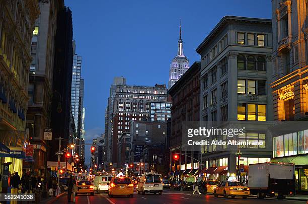 View at night of 6th Avenue, Manhattan and Empire State Building. City, urban, night, avenue, street, car, cars, busy, dusk, skyline, cityscape,...