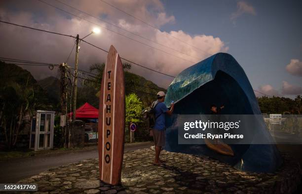 Child is photographed by his father on the Teahupo'o wave monument at 'The End of the Road' on August 17, 2023 in Teahupo'o, French Polynesia....