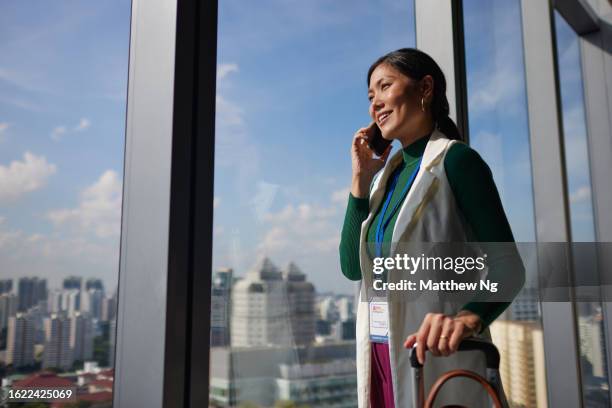 business travel - a beautiful asian female professional on business trip checking into the hotel - succession planning stock pictures, royalty-free photos & images