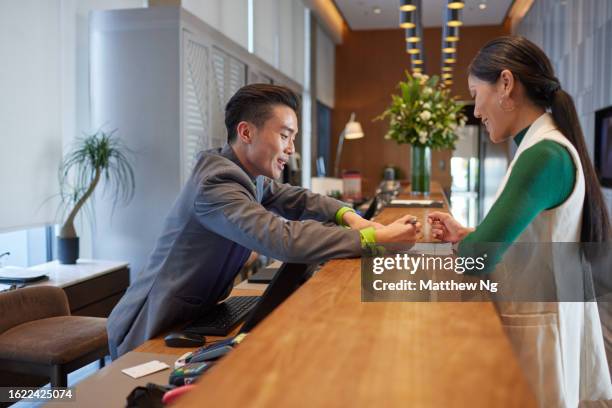 business travel - a beautiful asian female professional on business trip checking into the hotel - succession planning stock pictures, royalty-free photos & images