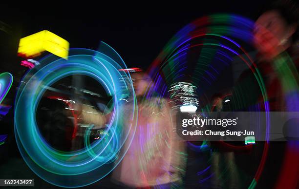 South Koreans spin illuminated cans during 'Cyber Jwibulnoli' at Everland on February 21, 2013 in Seoul, South Korea. Jwibulnoli is originally played...