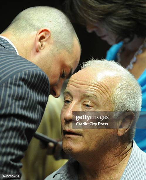 Oscar Pistorius's brother, Carl Pistorius, comforts their father, Henk Pistorius, during Oscar's bail hearing in the Pretoria Magistrate Court on...