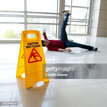 Slipped Sign Man Slipped On Wet Floor With Wet Floor Sign Nearby High-Res Stock ...