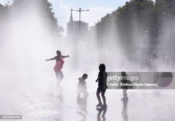 People cool off at a splash pad during a hot day in Vienna, Austria, on Aug. 22, 2023.