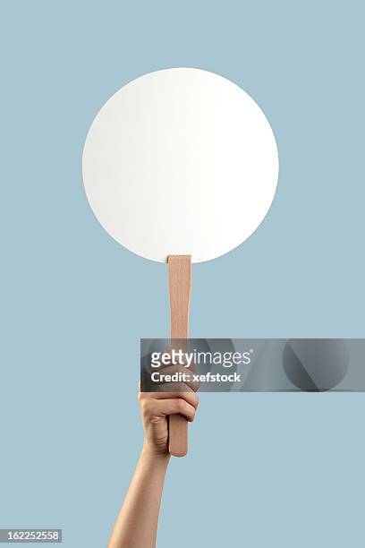 white auction placard with a hand holding it up - placard stockfoto's en -beelden