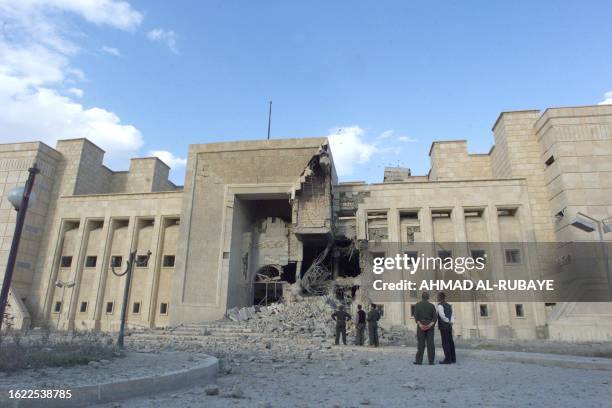 Iraq's ruling Baath party officials look at the Tikrit museum 22 March 2003 that was hit the night before by a US missile. Four Iraqis were killed in...