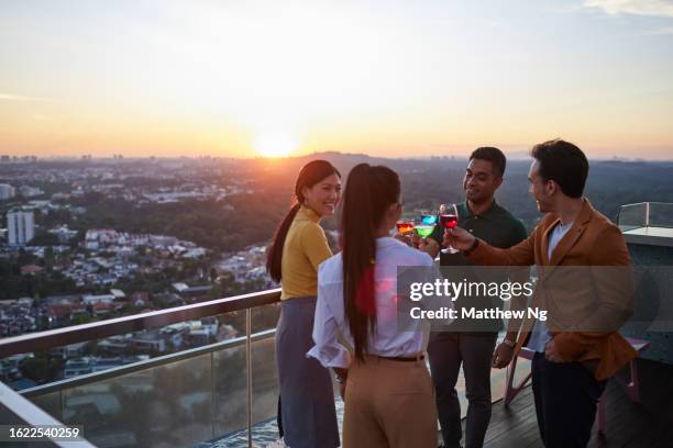 schöne asiatische geschäftsfrauen und geschäftsmänner treffen sich nach einer konferenzveranstaltung zu getränken und gesprächen in einer bar auf dem dach - cocktail sonnenuntergang stock-fotos und bilder