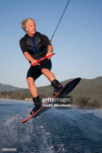 mid forties male jumping on his wakeboard - pend orielle lake stock pictures, royalty-free photos & images