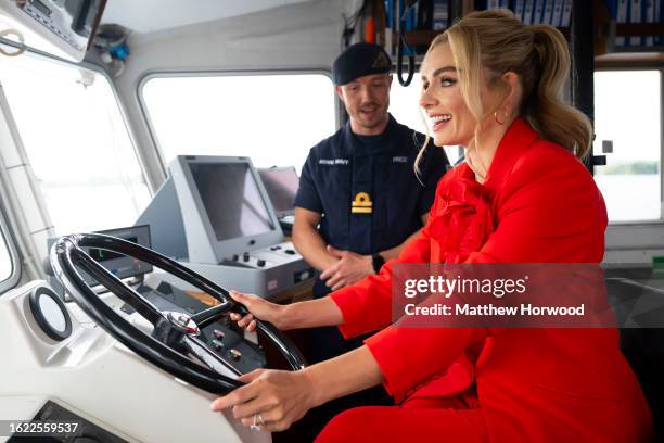 Katherine Jenkins sits at the controls of HMS Express with Lieutenant Ryan Price as she is named as the sponsor of HMS Cardiff on August 25, 2023 in...