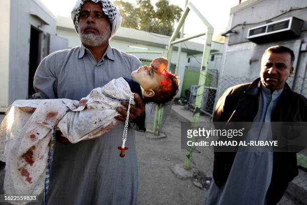 An Iraqi carries the body of his grandson out of the morgue of a hospital in Baghdad 21 November 2006. The child was killed according to his...