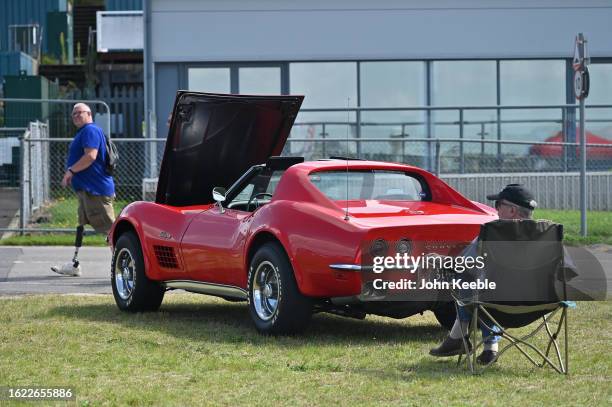 An owner sits by his vintage classic Corvette Stingray during the British Motor Show at Farnborough International Exhibition Centre on August 17,...