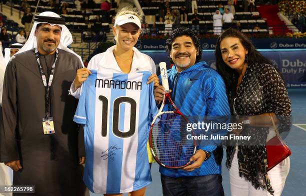 Caroline Wozniacki of Denmark exchanges gifts with football legend Diego Maradona as they pose for a picture with Salah Tahlak, Tournament Director...