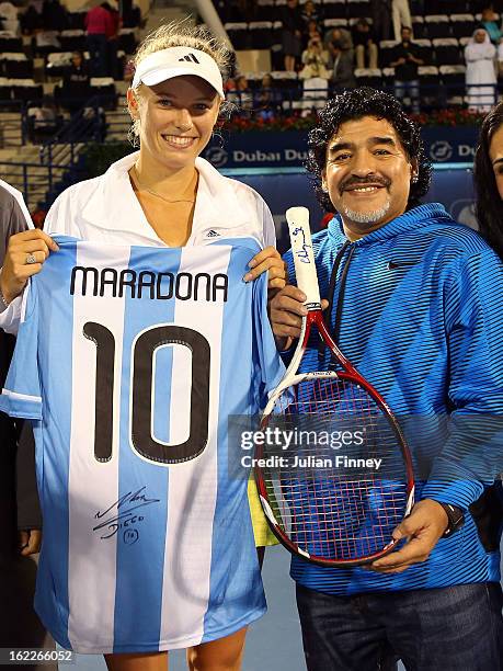 Caroline Wozniacki of Denmark exchanges gifts with football legend Diego Maradona as they pose for a photo during day four of the WTA Dubai Duty Free...