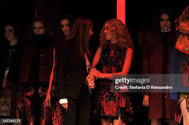 Designer Eva Cavalli is congratulated by model Georgia May Jagger and her other models as she acknowledges the applause of the audience after the...