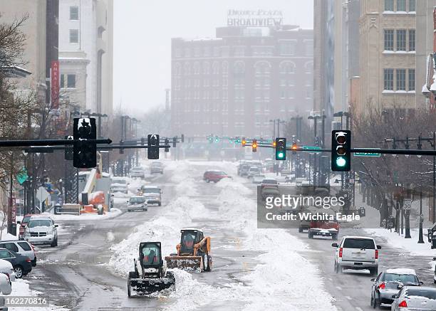 Crews work to clean snow off Douglas Avenue in downtown Wichita, Kansas, Thursday, February 21, 2013. Wichita received several inches of snow during...