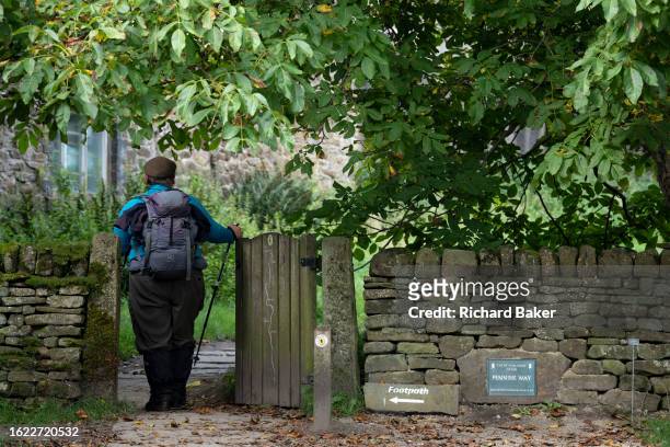 Walker opens and closes the gate at the beginning of the Pennine Way at Edale in the Peak District National Park, on 24th August 2023, in Sheffield,...