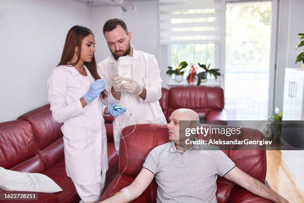 iv drip chemotherapy administered for cancer patient by staff - administered stock pictures, royalty-free photos & images