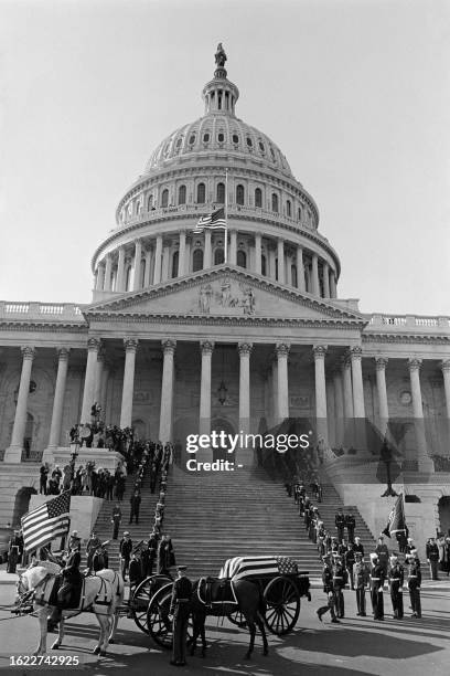 The flag-draped coffin of late US President John Fitzgerald Kennedy, carried by a horse-drawn caisson driven by honor guards, leaves the Capitol...