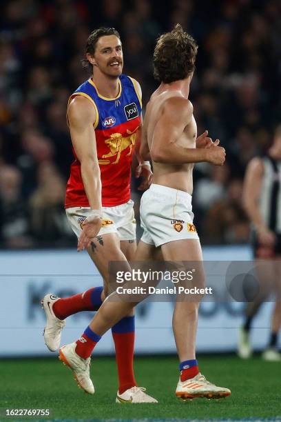 Joe Daniher of the Lions reacts to Deven Robertson of the Lions after having removed his torn guernsey during the round 23 AFL match between...
