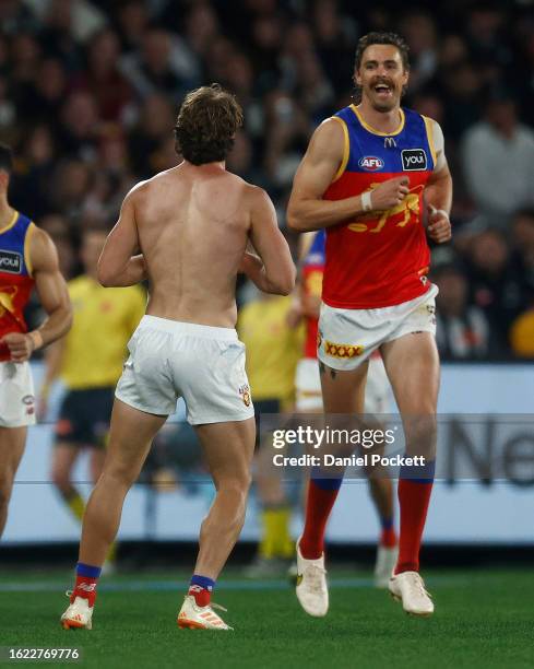 Joe Daniher of the Lions reacts to Deven Robertson of the Lions after having removed his torn guernsey during the round 23 AFL match between...