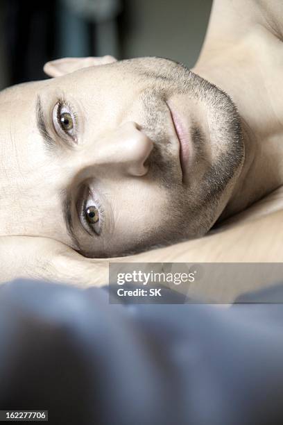 man with designer stubbles lying in bed, portrait - lying on side stock-fotos und bilder