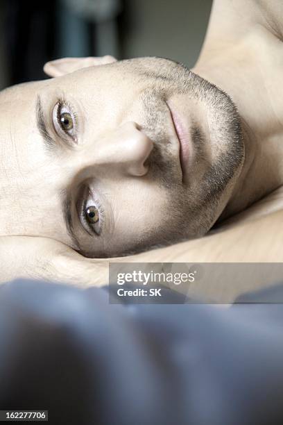 man with designer stubbles lying in bed, portrait - lying on side stock pictures, royalty-free photos & images