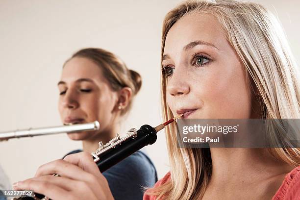 two teenage girls playing oboe and transverse flute - flute traversiere photos et images de collection