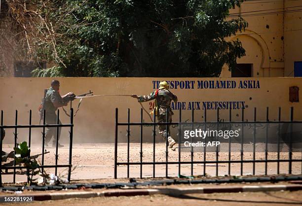 Malian soldiers shoot with a light machine gun as they fight after clashes erupted in the city of Gao on February 21, 2013 and an apparent car bomb...