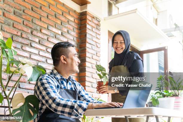 asian man recording their sales data on laptop - brick patio stock pictures, royalty-free photos & images