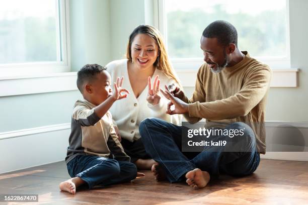 mixed race family with young boy, counting with fingers - three fingers stock pictures, royalty-free photos & images