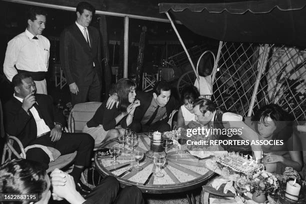 Trevor Howard célébrant son anniversaire entouré de Harold Sakata, Jocelyn Lane, Trini Lopez et Sylvia Sorrente sur le tournage du film 'Opération...