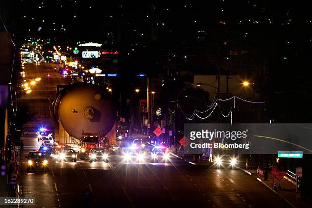 Steel coke drum is escorted by police as it is transported on a trailer manufactured by Mammoet Salvage BV along the Pacific Coast Highway in Hermosa...