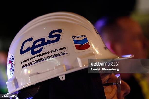 Worker wearing a hard hat monitors the transport of steel coke drums in Redondo Beach, California, U.S., on Wednesday, Feb. 20, 2013. The drums,...