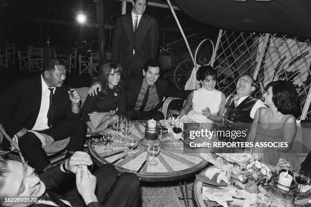 Trevor Howard célébrant son anniversaire entouré de Harold Sakata, Jocelyn Lane, Trini Lopez et Sylvia Sorrente sur le tournage du film 'Opération...