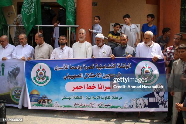 Palestinian supporters of the Islamic Resistance Movement Hamas raise green Islamic banners and flags during a demonstration in solidarity against...