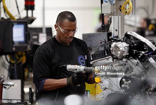 An employee assembles an 2.0 liter ecoboost engine on the production line at the Ford Motor Co. Cleveland Engine Plant in Brook Park, Ohio, U.S., on...
