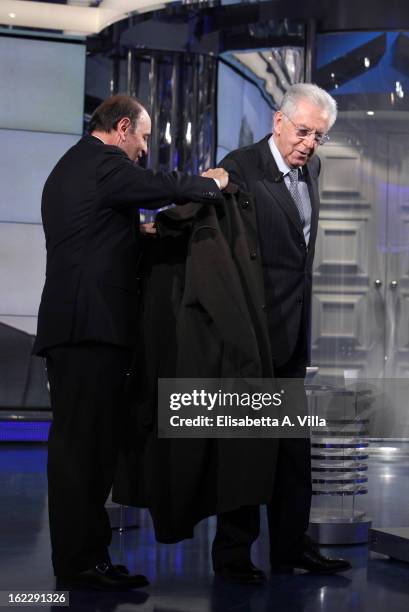 Presenter Bruno Vespa helps Italian Prime Minister Mario Monti try on a Loden coat during filming for the 'A Porta A Porta' TV Show on February 21,...