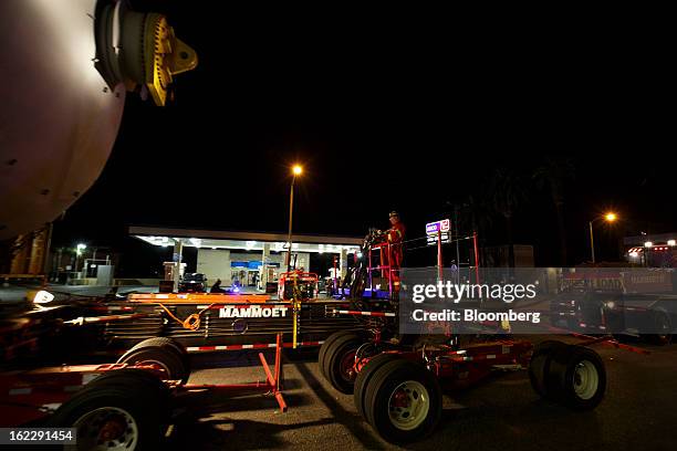 Worker guides a trailer manufactured by Mammoet Salvage BV as it transports a coke drum along the Pacific Coast Highway in Hermosa Beach, California,...