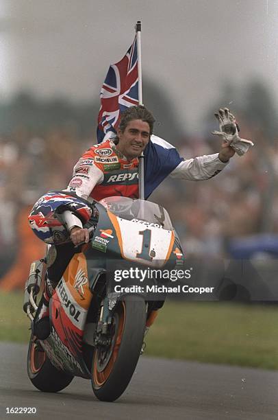 Michael Doohan of Australia celebrates his fourth successive world 500cc title at the British Motorcycle Grand Prix at Donington Park, England. \...