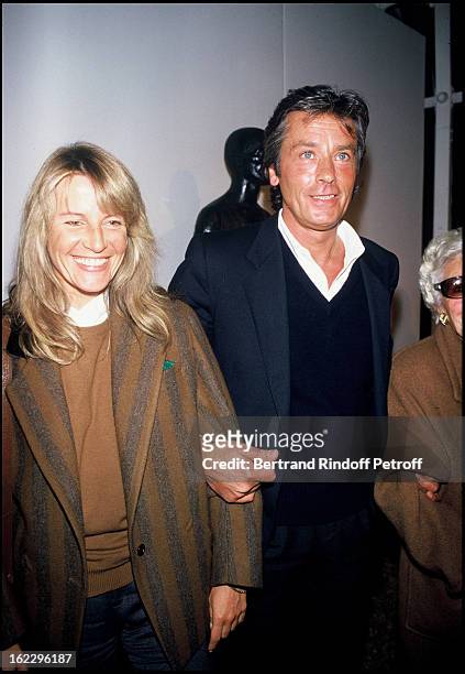 Alain Delon with his girlfriend Catherine Pironi at sculptor Paul Belmondo's exhibition.