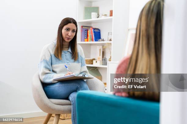 conversation with a young female therapist. attending therapy with psychologist counselor looking for advice - lettino-dello-psicoanalista foto e immagini stock