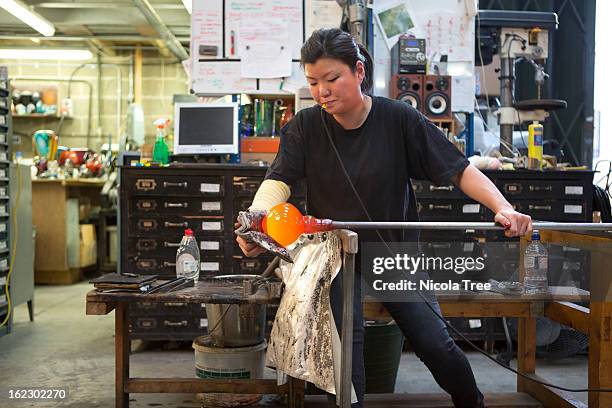 glassblower blowing molten glass making a vase - glass blowing stock pictures, royalty-free photos & images