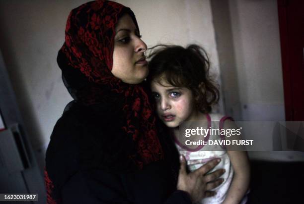 Palestinian refugee holds her daughter after they were evacuated from the besieged Palestinian refugee camp of Nahr al-Bared in northern Lebanon to...