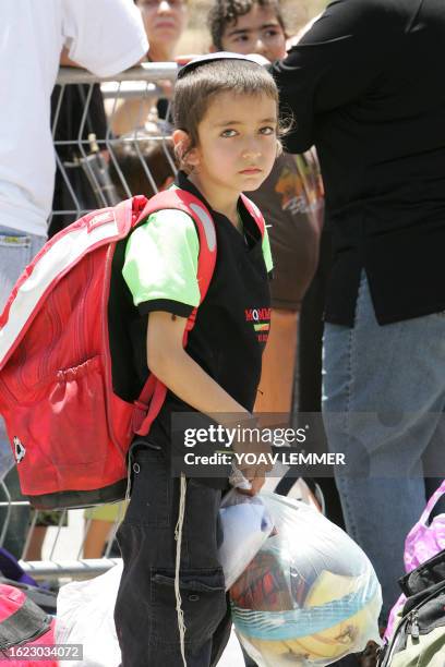 An Israeli child from Sderot waits with others to board a bus to be evacuated from this southern Israeli town, 22 May 2007, as citizens fear more...
