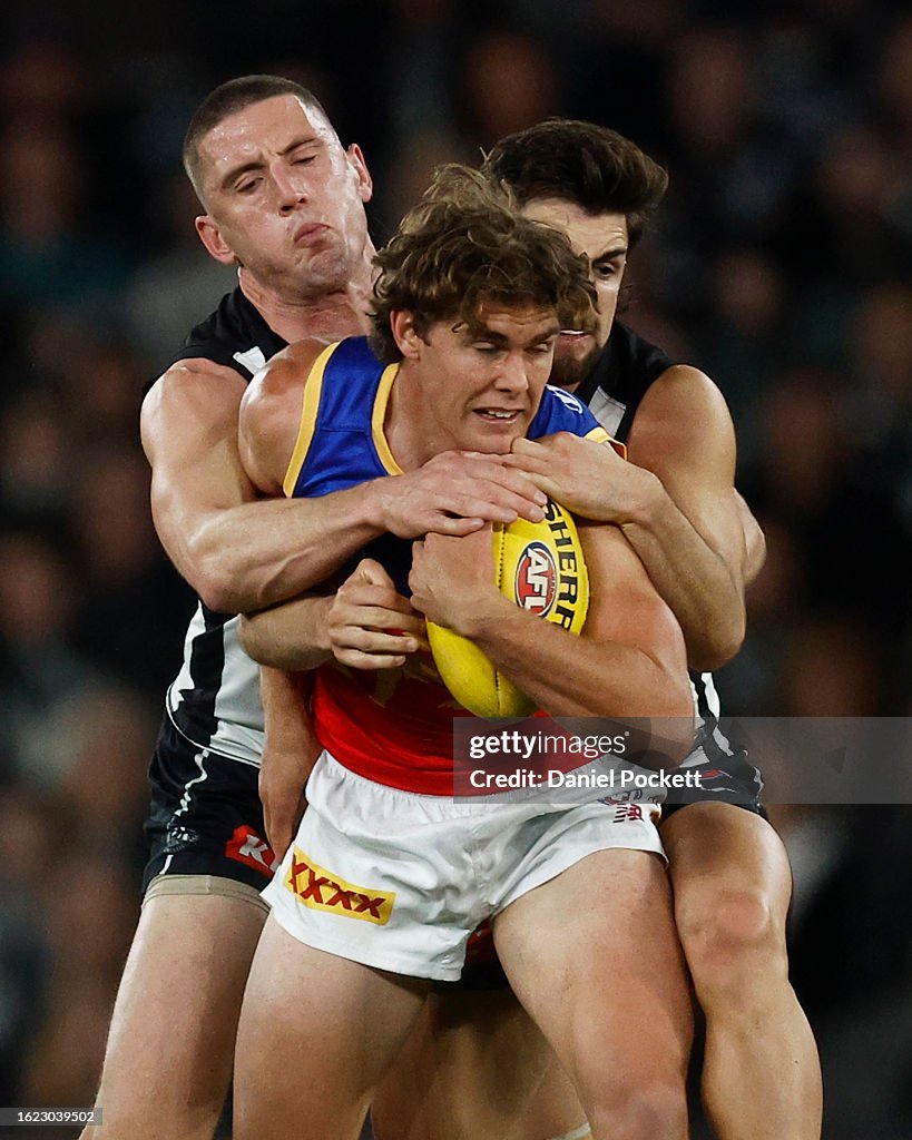 Deven Robertson of the Lions is tackled by Josh Daicos of the Magpies ...